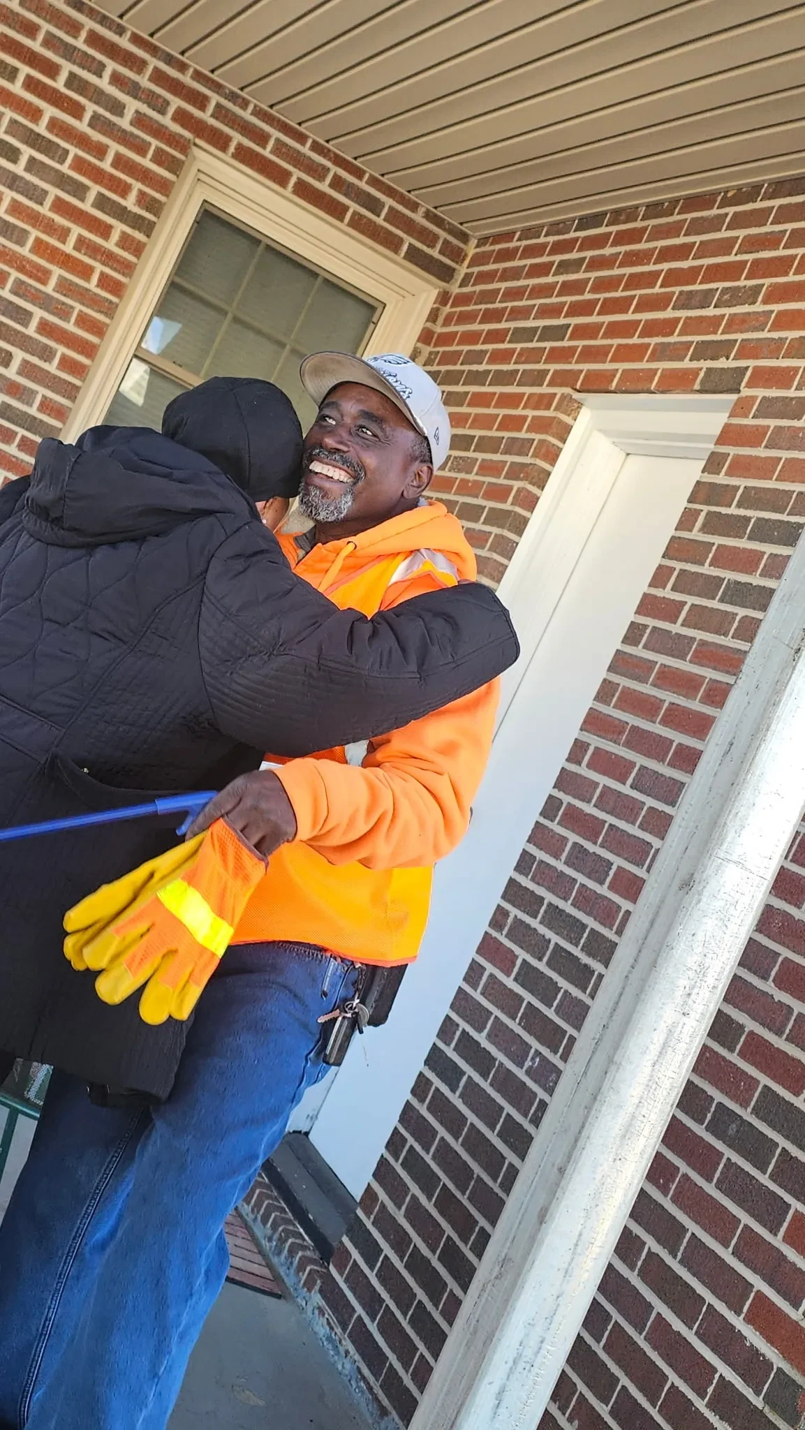 Community members sharing a warm embrace during an Adopt-a-Highway service day