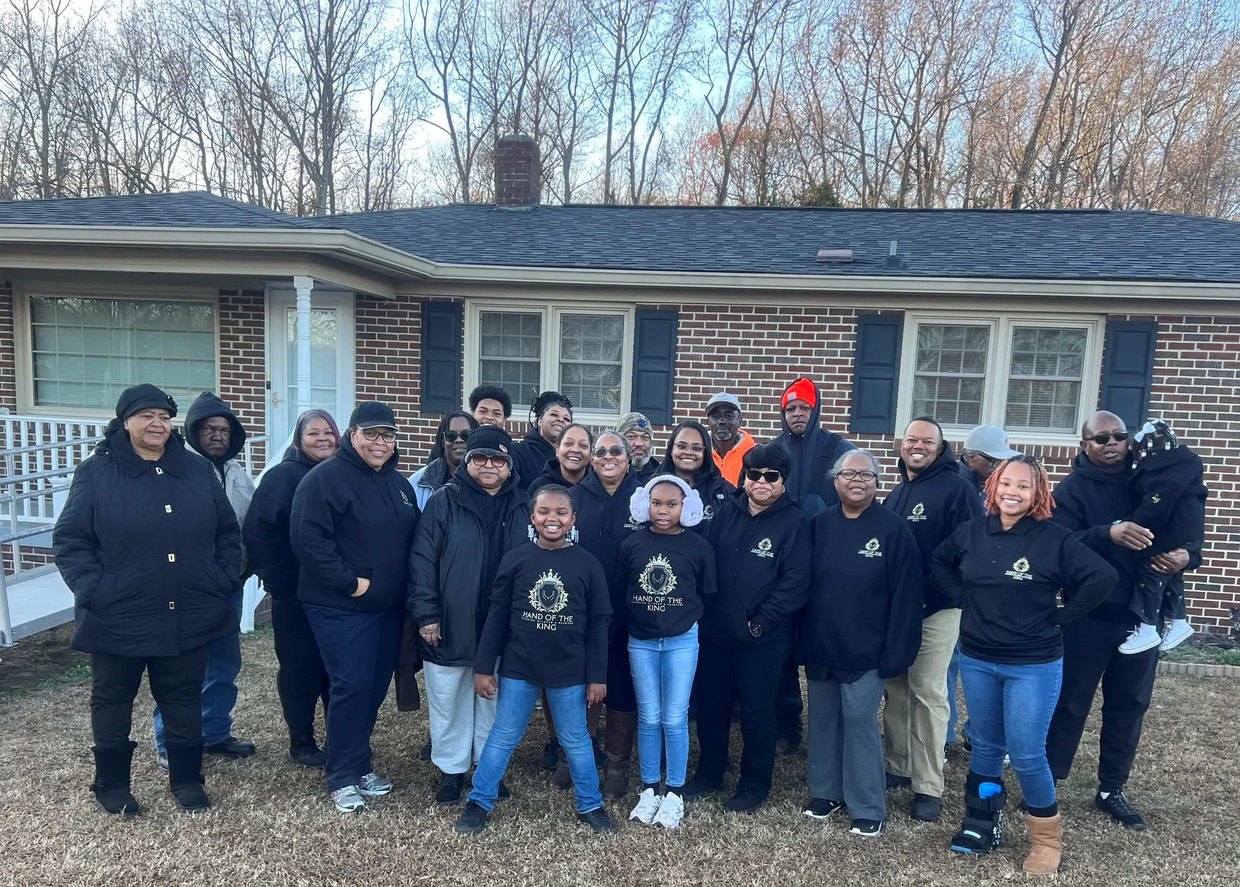 Hand of the King volunteers gathered outside during a community cleanup