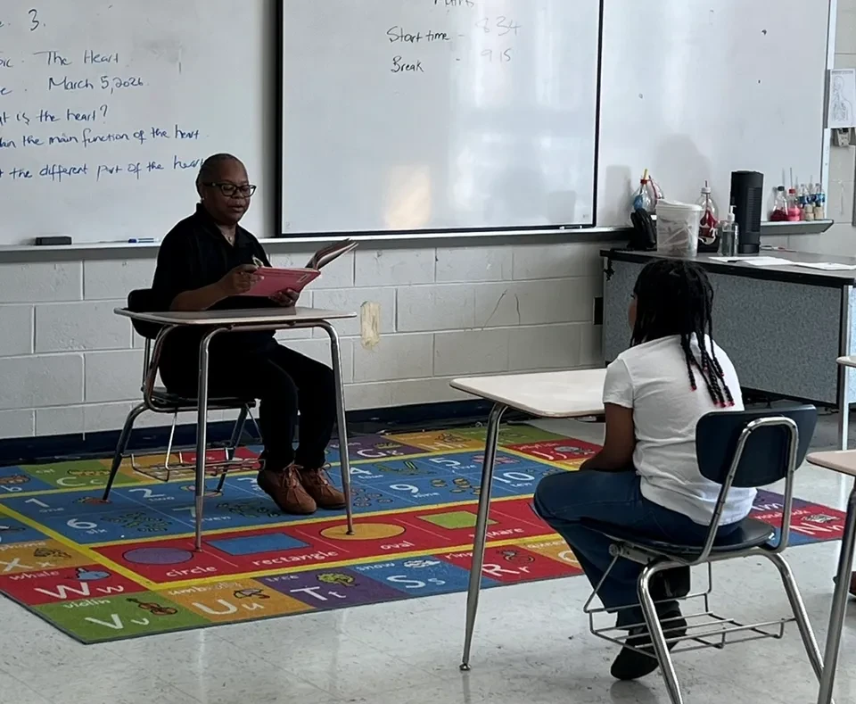Hand of the King volunteer reading with a student in a classroom