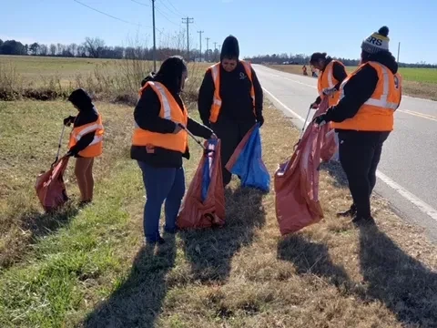 Hand of the King volunteers collecting litter along a rural roadside