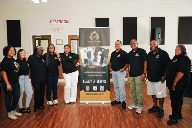 Advisory Council G2s team members in Hand of the King shirts beside the Legacy of Service banner