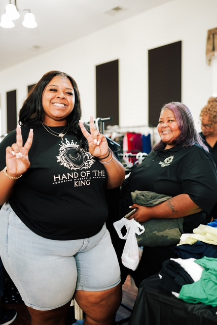 Two Hand of the King volunteers smiling at the Clothing Giveaway event