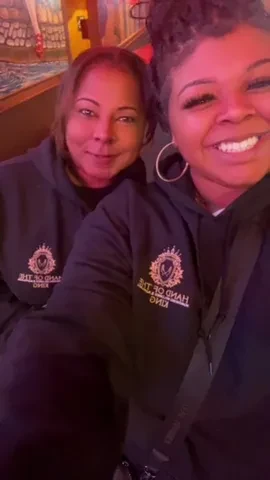 Two Hand of the King volunteers smiling together in matching hoodies