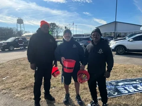 Three Hand of the King volunteers standing outdoors during a community service event