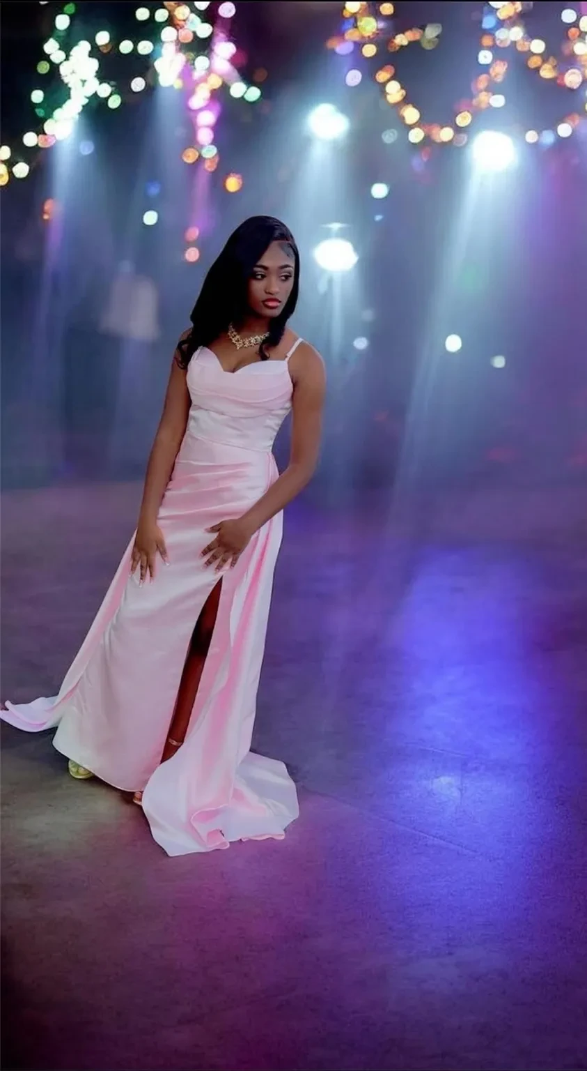 Young woman in a pale pink gown at a colorful event