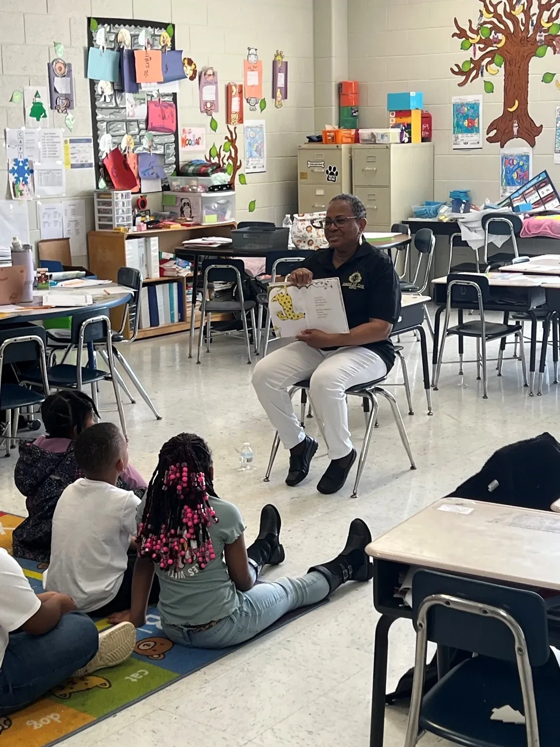 Hand of the King volunteer reading to children in a classroom