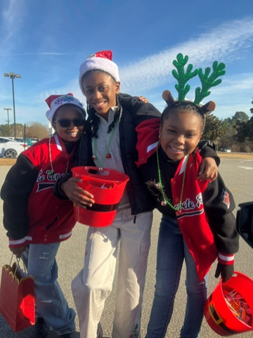 Three children participating in a Hand of the King holiday service event