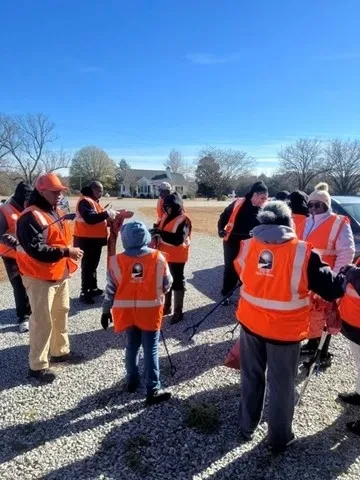 Hand of the King volunteers wearing orange safety vests during a community service activity